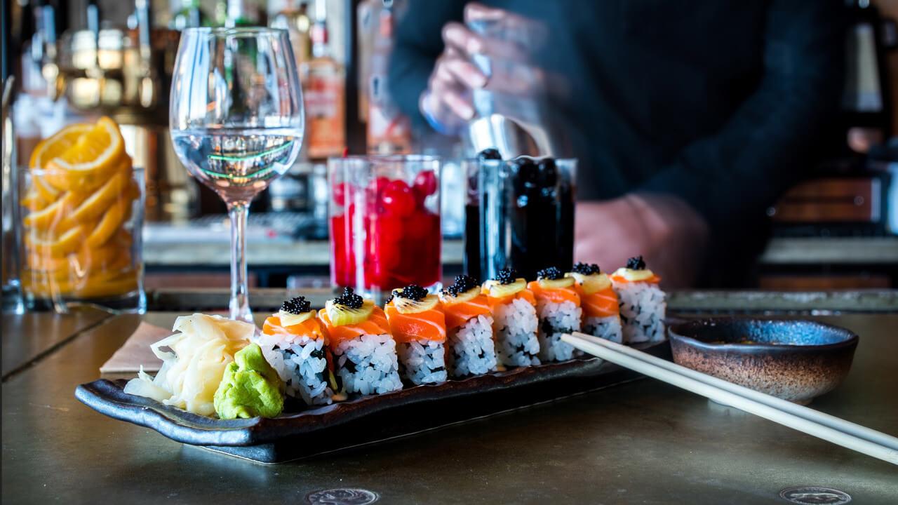 A plate of sushi and glass of wine